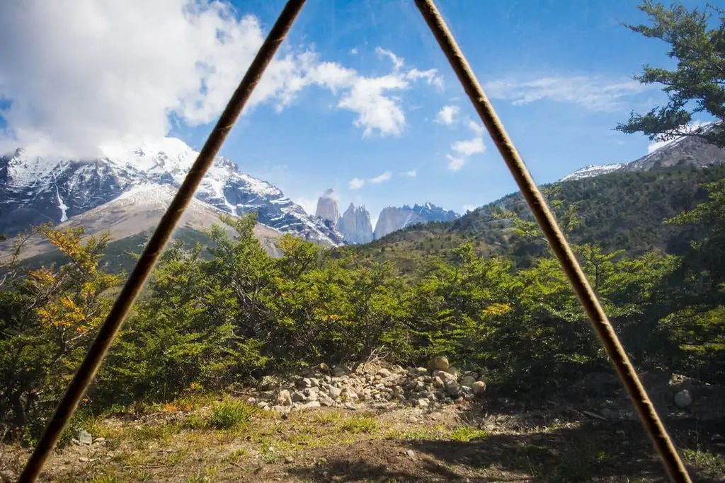 Geodesic dome suites nestled in mountainous Patagonian landscape at sunset, with snow-capped peaks and native forest in background