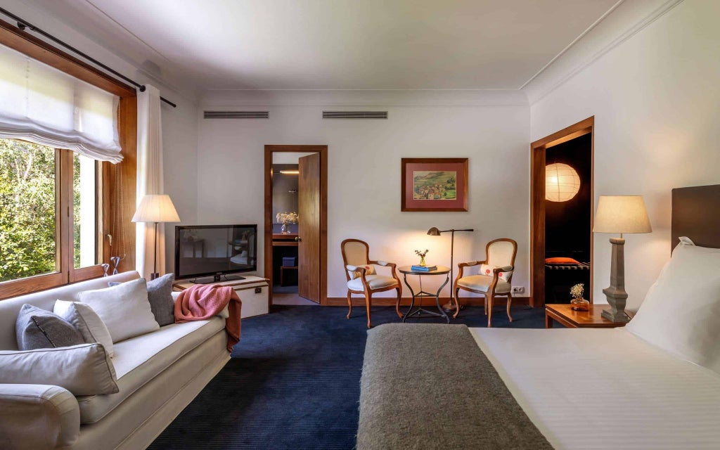 Elegantly designed superior hotel room with modern decor, plush white bedding, sleek wood furnishings, and soft ambient lighting in Primero Primera Hotel & Club, Spain.