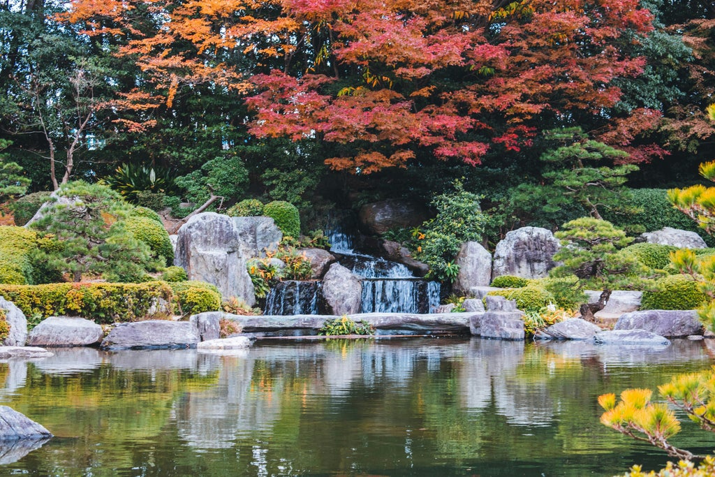 Traditional Japanese temple with golden autumn leaves, elegant stone pathway, and serene Dazaifu landscape showcasing cultural heritage and seasonal beauty of Japan