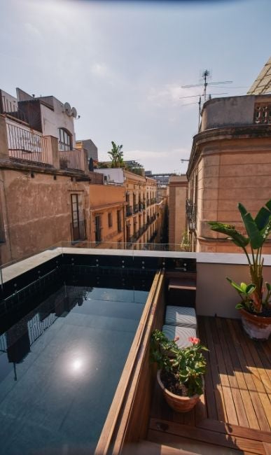 Elegant stone facade of Hotel Neri Barcelona with ornate balconies, arched windows and vintage lanterns adorning medieval architecture