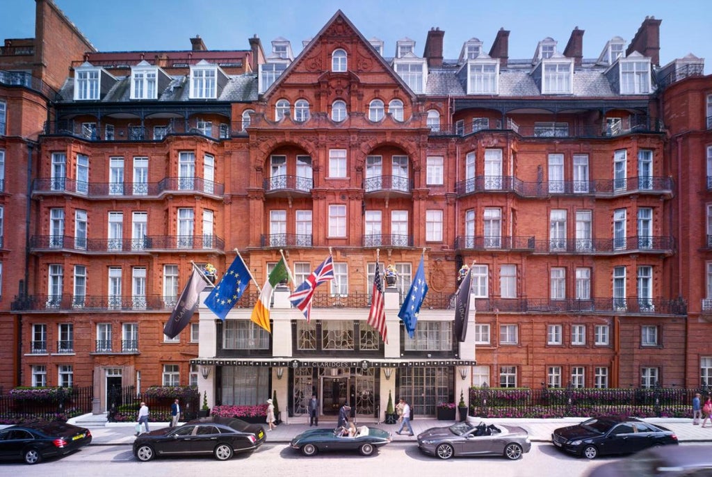 Elegant Art Deco facade of Claridge's Hotel in Mayfair, London, featuring ornate stonework, signature green awnings and vintage lampposts