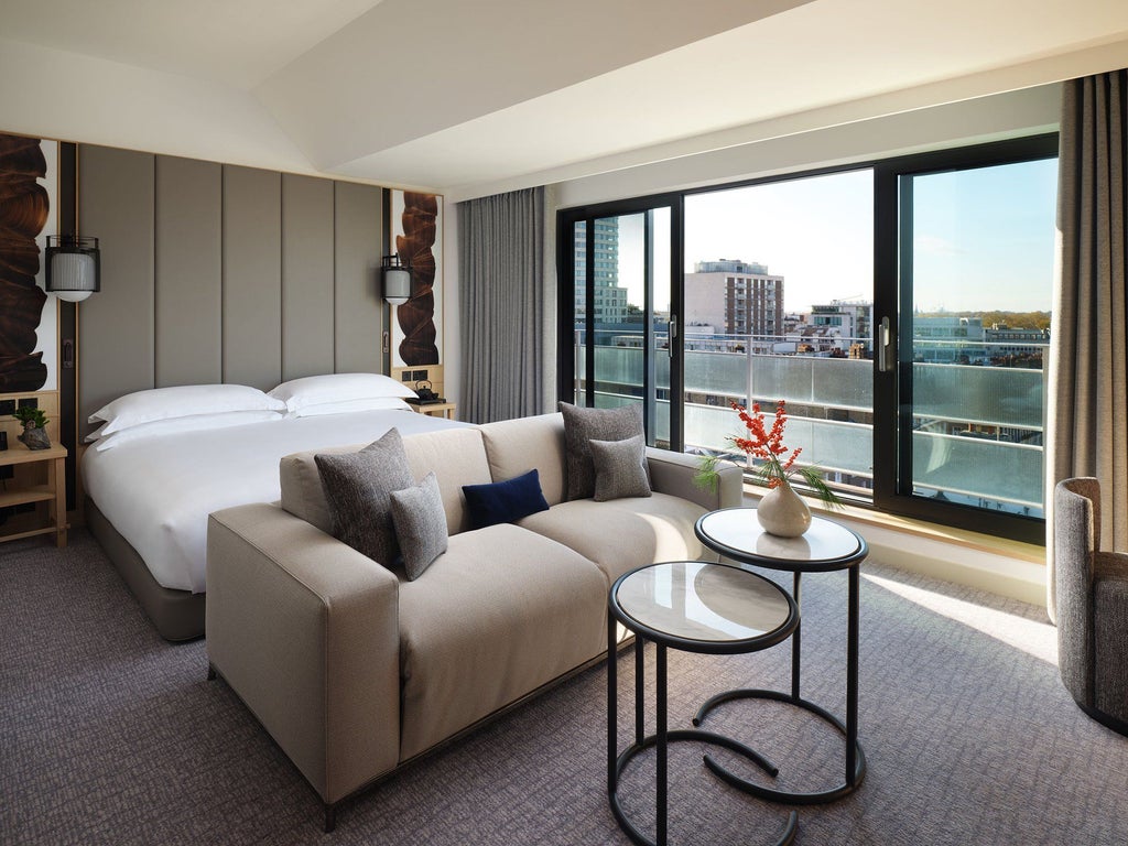 Luxurious junior suite at Nobu Hotel London Portman Square with modern minimalist decor, plush king bed, and city-view window overlooking urban landscape