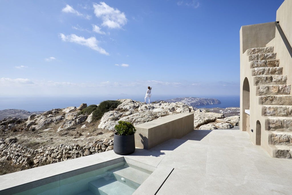 Luxurious white-washed Cycladic hotel with blue-domed roofs overlooking azure Aegean Sea, perched dramatically on Santorini's volcanic cliffs at sunset