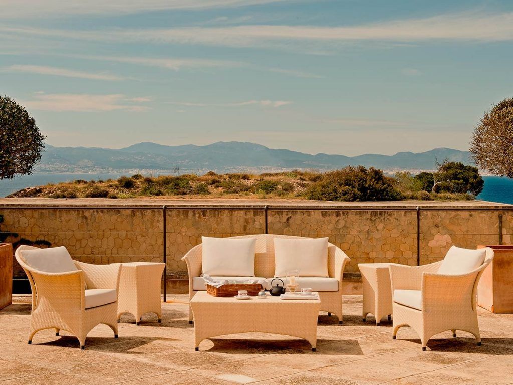 Historic fortress-turned-luxury hotel Cap Rocat perched on Mallorca's cliffs with infinity pool overlooking Mediterranean Sea at sunset