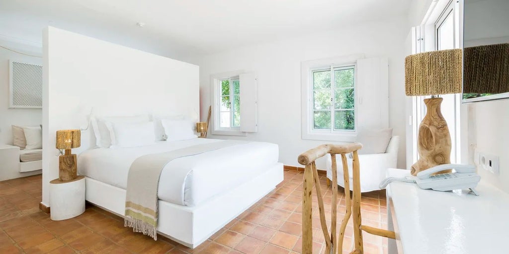 Elegant whitewashed Superior Room at Octant Vila Monte, featuring minimalist design, crisp linens, and warm natural light in a serene Portuguese setting