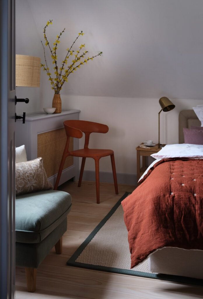 Rustic corner barn suite at Bethlen Estates, featuring exposed wooden beams, elegant linens, and traditional Transylvanian architectural details in soft, warm lighting