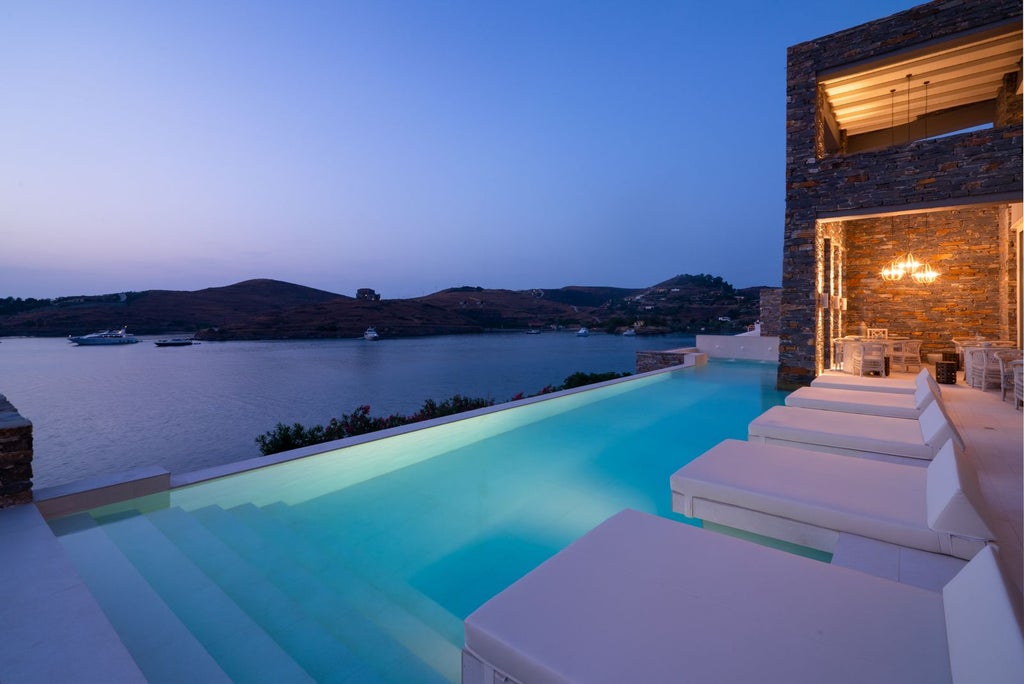 Luxurious whitewashed Cycladic suites with private pools overlooking Oia's blue-domed churches and stunning Aegean Sea sunset in Santorini, Greece