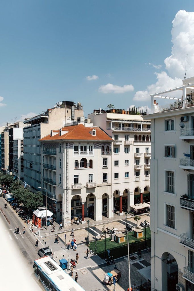 Minimalist hotel lobby with sleek marble reception, modern art, and soft lighting, showcasing elegant Thessaloniki design with urban sophistication and contemporary Greek aesthetics.