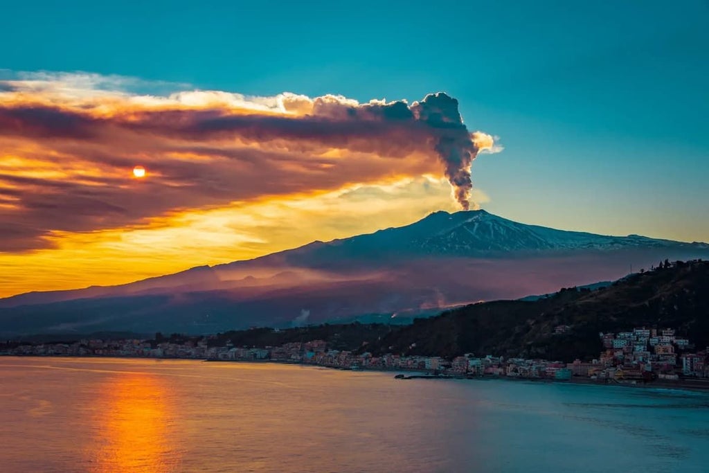 Luxurious rustic Sicilian estate with stone buildings, lush vineyards, and Mount Etna backdrop, showcasing elegant Mediterranean countryside retreat