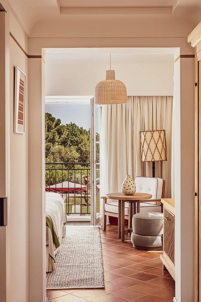 Luxurious stone-walled Saint-Tropez hotel terrace with lush bougainvillea, chic outdoor seating, and golden Mediterranean sunlight filtering through greenery