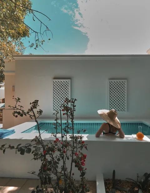 Luxurious white-washed suite with minimalist design, high ceilings, and elegant Portuguese decor, featuring a spacious bedroom with natural light