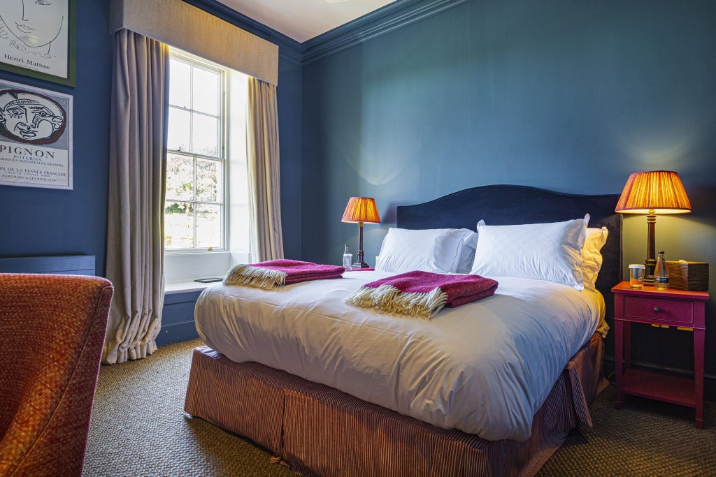 Elegant classic double room at The Talbot Malton, featuring plush white bedding, traditional wooden furnishings, and soft neutral color palette against warm lighting.