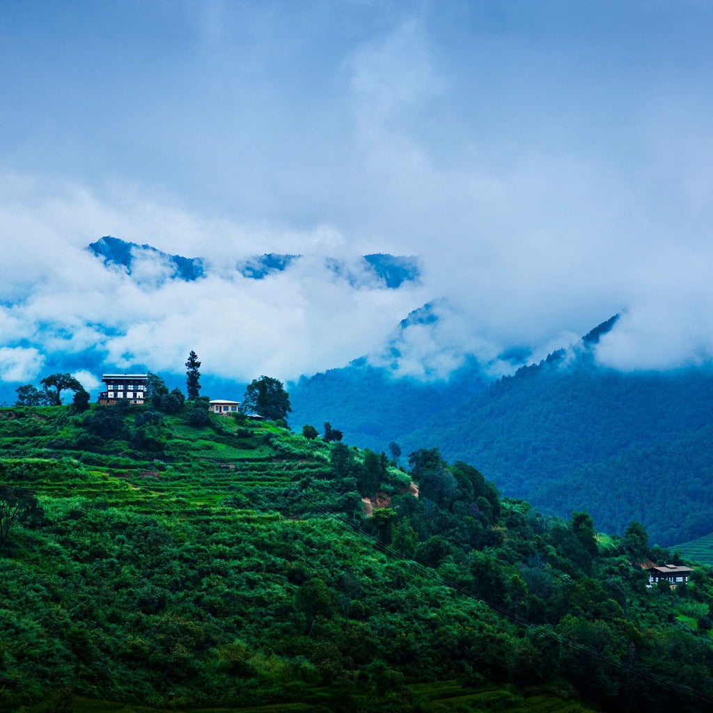 Luxurious stone and wood COMO Uma Paro hotel nestled in Bhutan's mountain landscape, featuring traditional architecture with sweeping Himalayan valley views