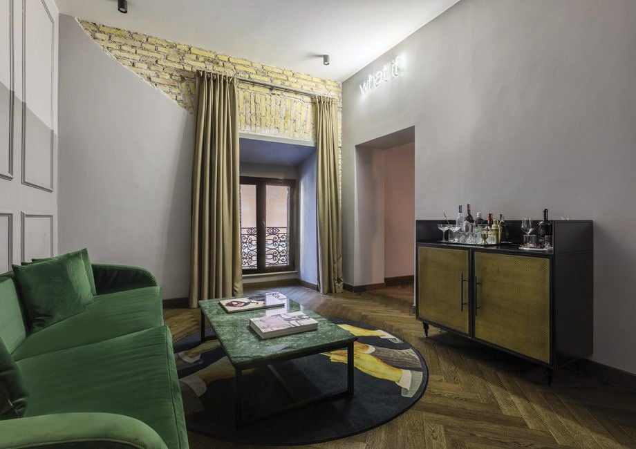 Elegant suite with plush king bed, marble bathroom, and city view at Chapter Roma hotel, featuring sophisticated contemporary Italian design elements