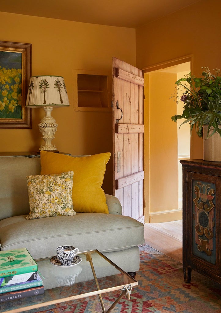 Luxurious cottage suite with sage green walls, plush king bed, vintage wooden furniture, and soft natural light in a charming UK countryside retreat