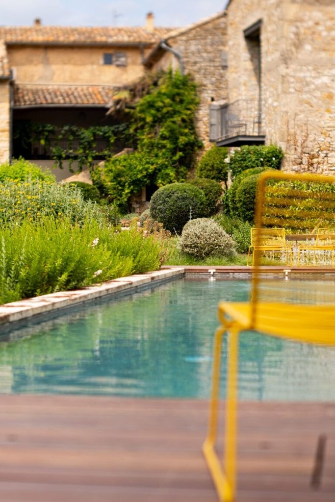 Rustic stone farmhouse with lavender fields, stone terrace, and elegant Provençal decor, capturing the luxurious charm of a boutique hotel in southern France