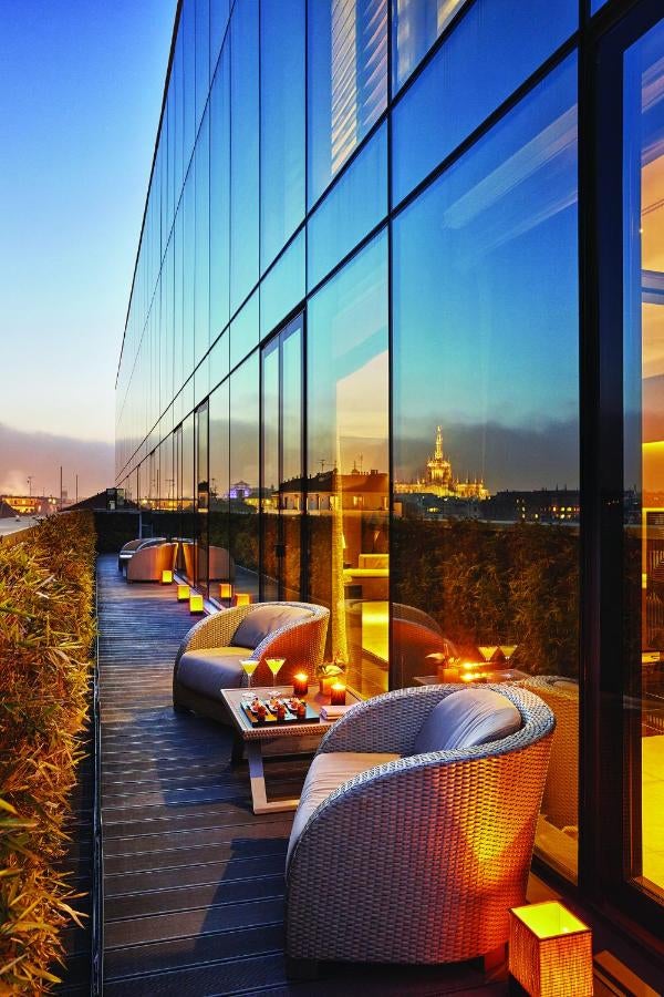 Luxurious hotel facade in Milan with sleek modern architecture, featuring floor-to-ceiling windows and minimalist design deta