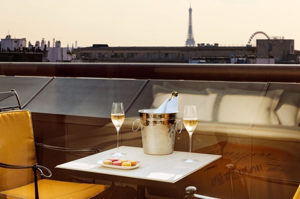 Elegant hotel room with floor-to-ceiling windows, private terrace, marble bathroom, and stunning Eiffel Tower views across Paris skyline