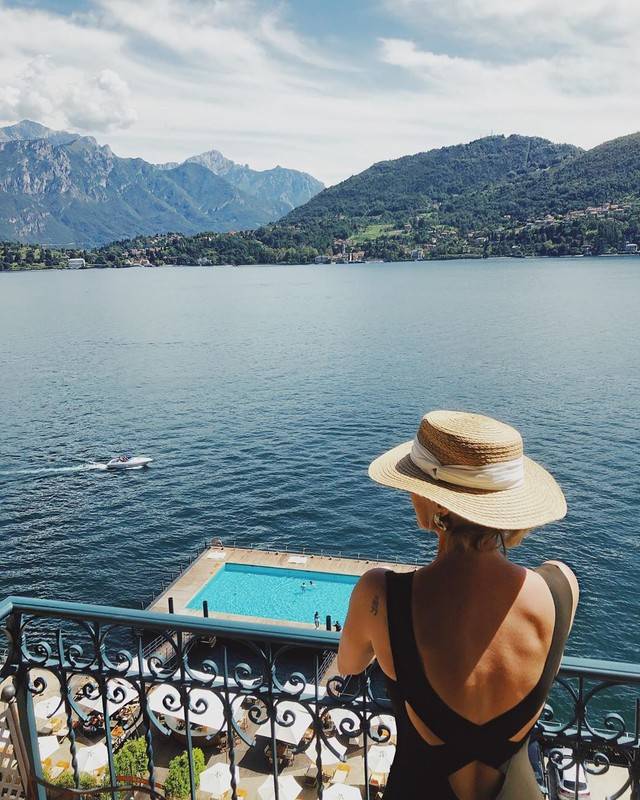 Elegant five-star lakeside hotel with Art Nouveau facade, featuring ornate balconies and terraces overlooking Lake Como's blue waters