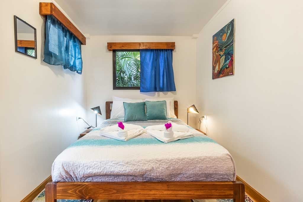 Modern beachfront hotel room with surf-inspired decor, wooden accents, ocean view, crisp white linens, and minimalist coastal design aesthetic