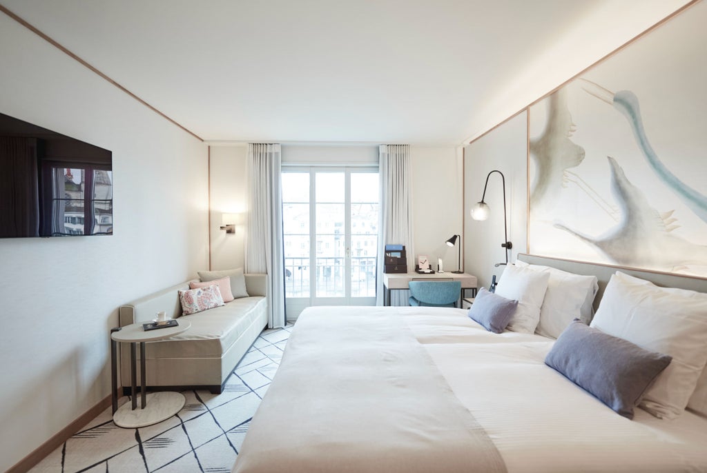 Elegant riverside double room with panoramic windows, plush king bed, classic wooden furniture, and warm lighting overlooking Zurich's waterfront