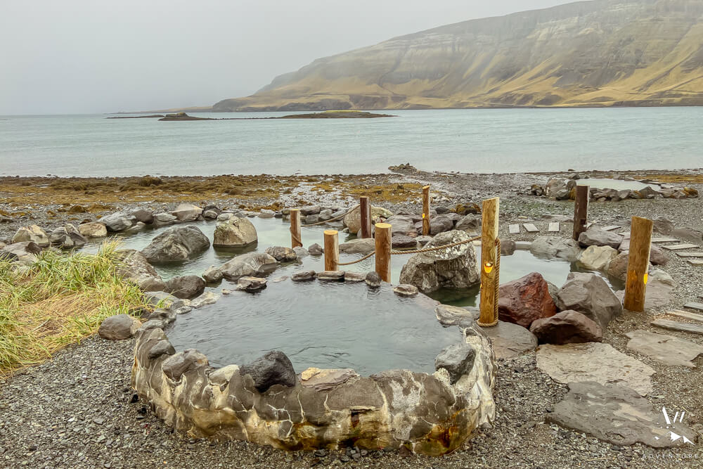 Steamy, natural hot springs nestled in rugged Icelandic landscape, with misty geothermal pools overlooking dramatic coastal scenery and rocky terrain