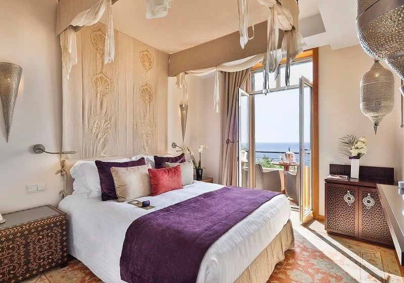 Luxurious deluxe sea view hotel room with elegant coastal decor, plush white bedding, and expansive windows overlooking Mediterranean scenery in Tiara Yaktsa Hotel, France