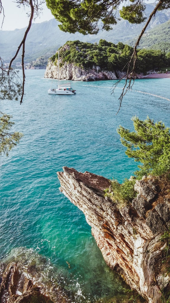 Luxurious private sailboat cruising crystal-clear Adriatic waters near Elafiti islands with rugged coastline and blue skies