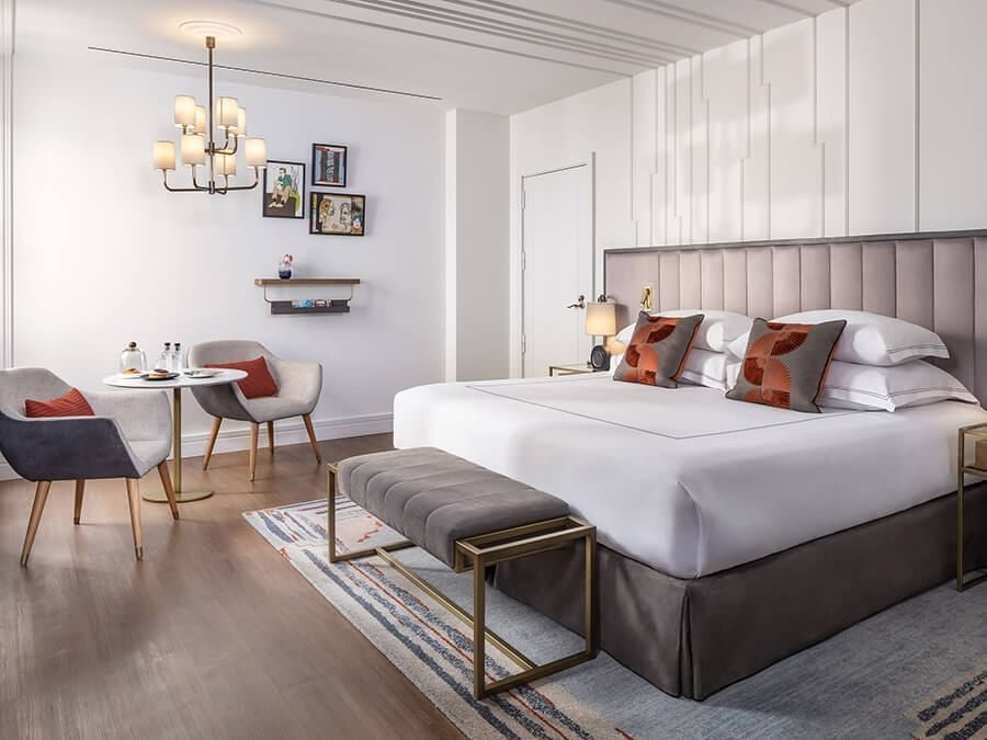 Elegant executive room at Gran Hotel Inglés with plush king bed, dark wood furnishings, soft neutral tones, and refined Spanish architectural details