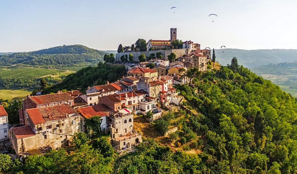 Aerial view of Dubrovnik's medieval stone walls and red-tiled roofs along the crystal-clear turquoise waters of the Adriatic Sea