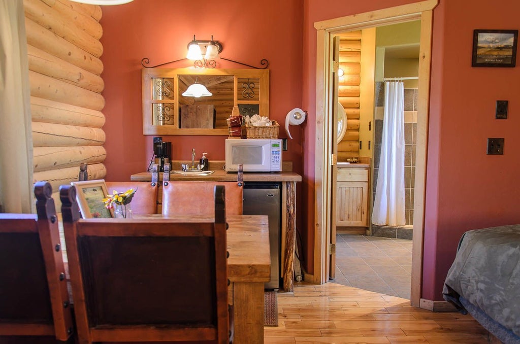 Rustic luxury cabin suite with wooden interiors, plush bedding, and panoramic mountain views at Scenset Mountain Ranch in scenic southwestern landscape