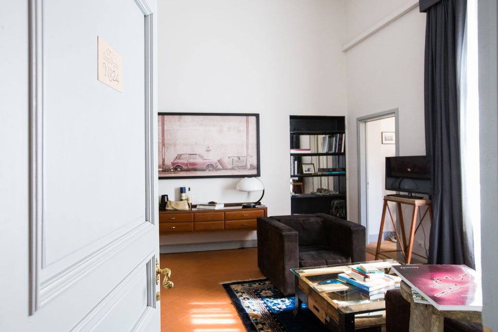 Elegant Italian deluxe hotel room with antique furnishings, rich wooden floors, and soft neutral tones bathed in warm natural light