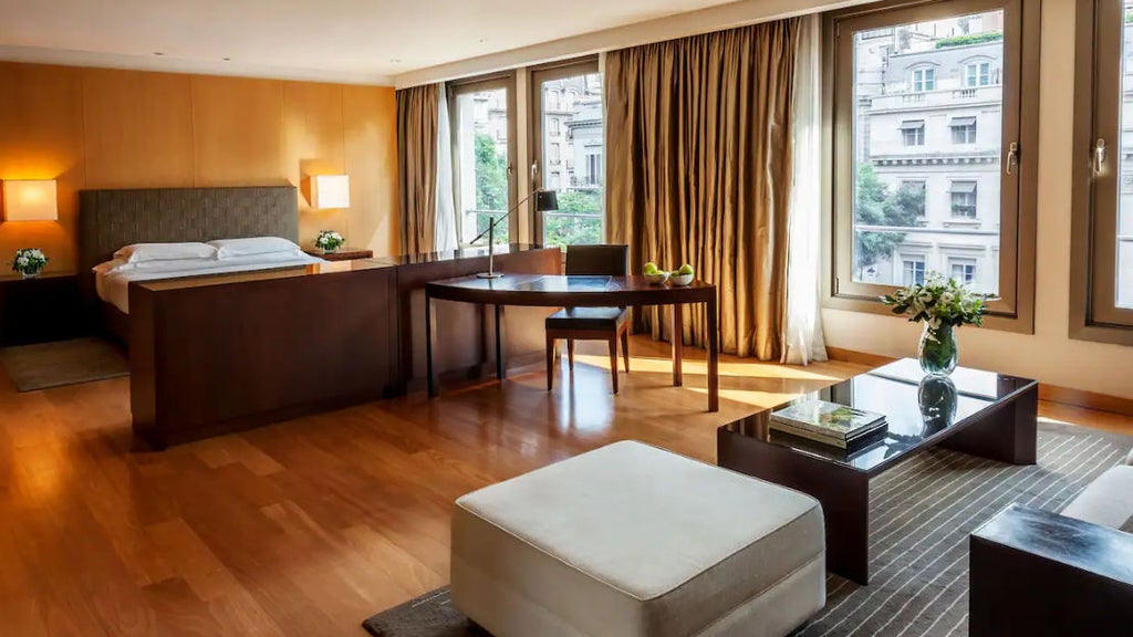 Elegant Park Suite bedroom with crystal chandelier, cream walls, king bed, French doors leading to balcony with Buenos Aires city views