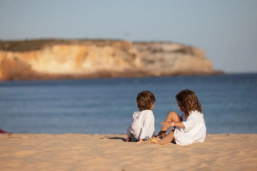 Luxurious beachfront resort in Sagres, Portugal, with modern white buildings, azure swimming pools, and stunning Atlantic Ocean coastline backdrop