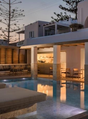 Luxurious white-washed Greek hotel overlooking azure Aegean waters, with elegant minimalist architecture and pristine infinity pool at sunset