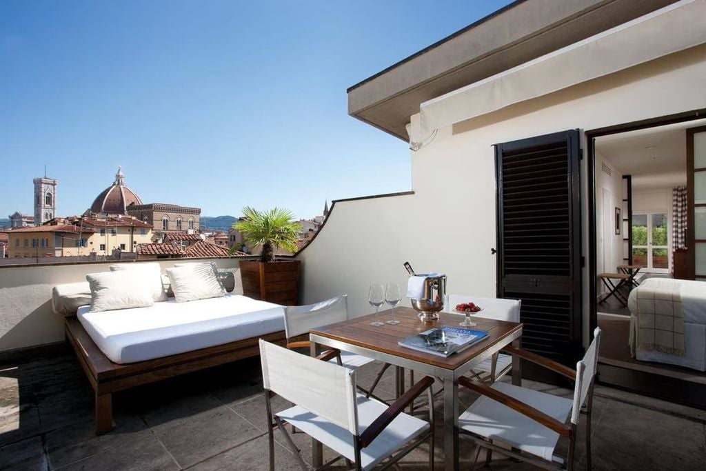 Elegant beige stone building of Gallery Hotel Art in Italy, featuring arched windows, ornate architectural details, and ambient lighting