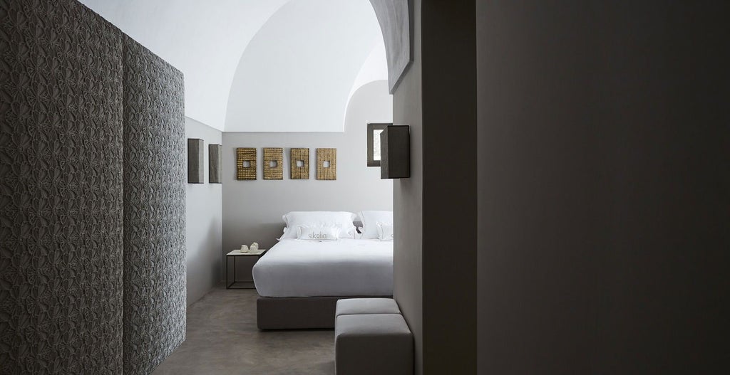 Elegant executive suite with minimalist white decor, plush king bed, expansive windows overlooking Sicilian landscape, contemporary Italian design, soft natural lighting