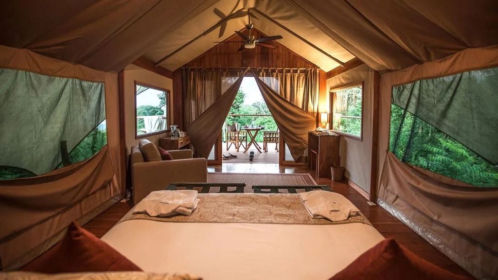 Luxurious eco-lodge with canvas safari-style tents overlooking lush Galapagos highlands, blending rustic elegance with sustainable wilderness retreat design