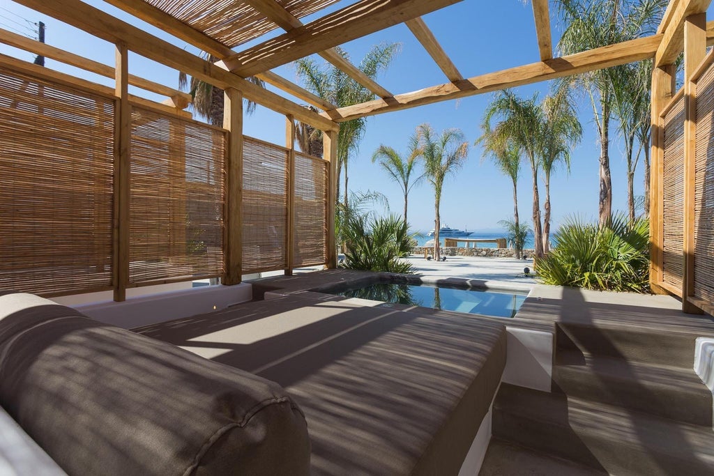 Luxurious white-themed Jacuzzi Sea View Suite at Branco Mykonos, featuring elegant minimalist design with panoramic Aegean Sea backdrop and private outdoor hot tub