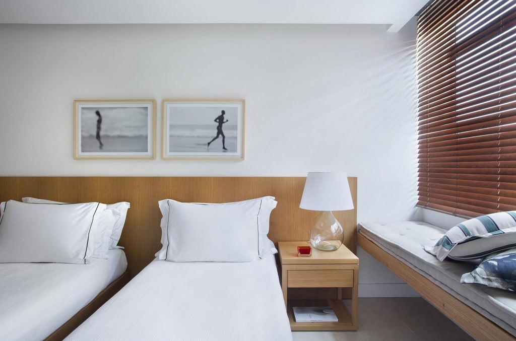 Elegant deluxe hotel room with panoramic coastal view, modern minimalist design, crisp white linens, and sleek Brazilian contemporary furnishings.