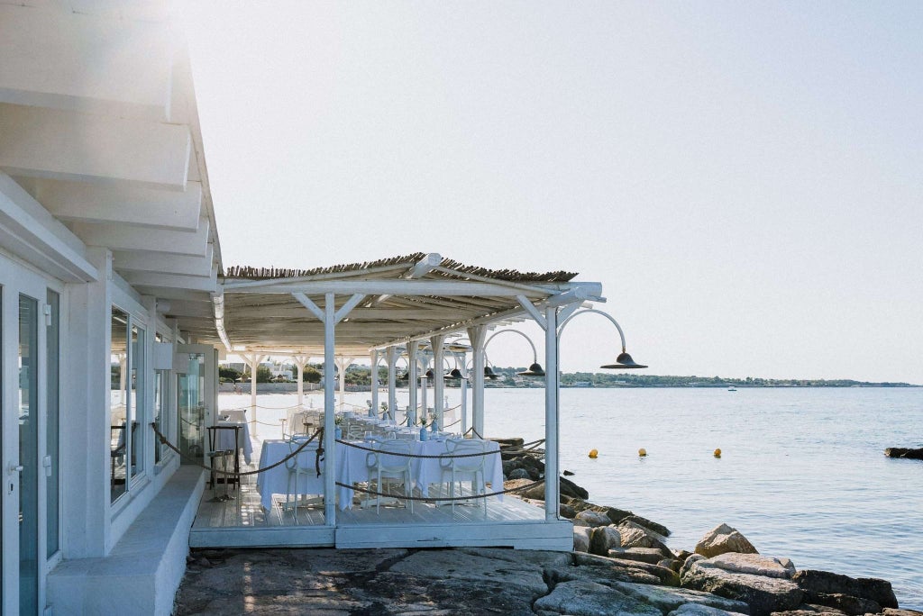 Elegant seaside hotel with infinity pool overlooking azure Adriatic waters, blending modern architecture with lush Mediterranean landscaping at scenic coastal location