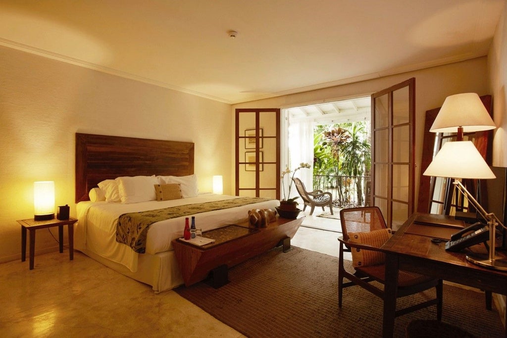 Elegant deluxe hotel room with private balcony overlooking Brazilian scenery, featuring sophisticated decor and luxurious serenity in historic Rio de Janeiro setting