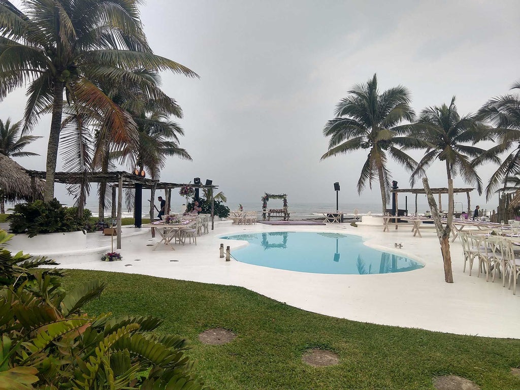 Luxurious white-washed Mexican boutique hotel with ocean view, tropical palm trees, and minimalist architectural design overlooking scenic coastline