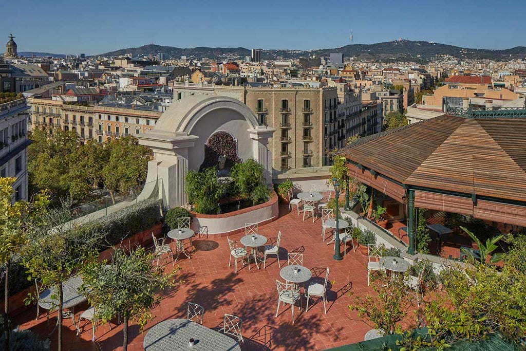 Grand neoclassical facade of El Palace Hotel Barcelona with ornate stone balconies, elegant arched windows and regal entrance canopy