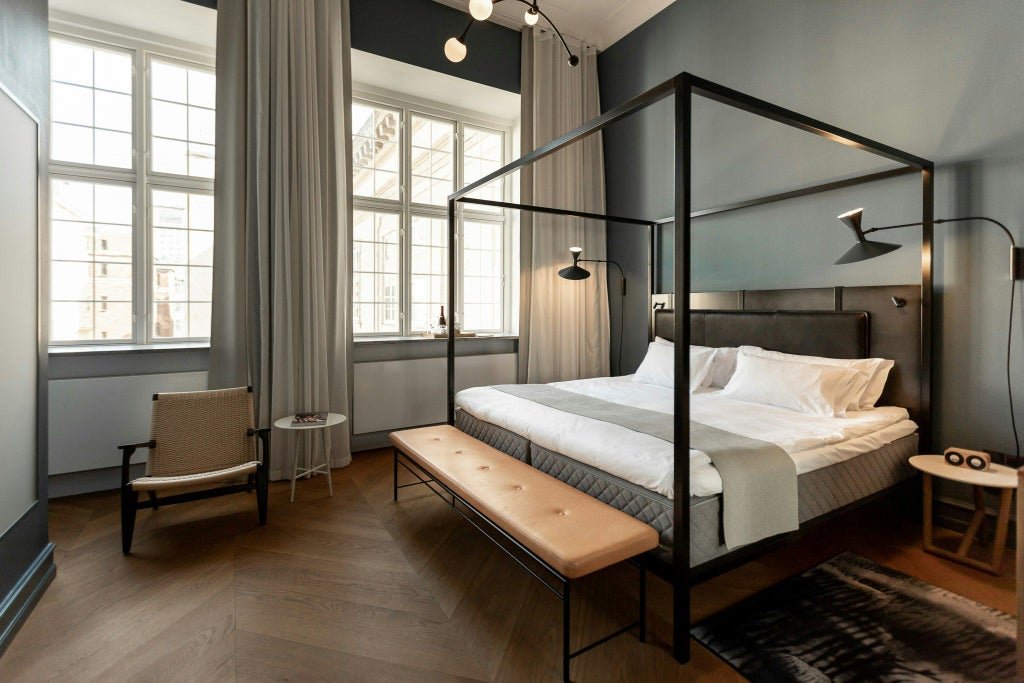 Elegant deluxe hotel room with minimalist Danish design, featuring sophisticated neutral tones, plush bedding, and sleek modern furnishings at scenset Hotel Copenhagen.