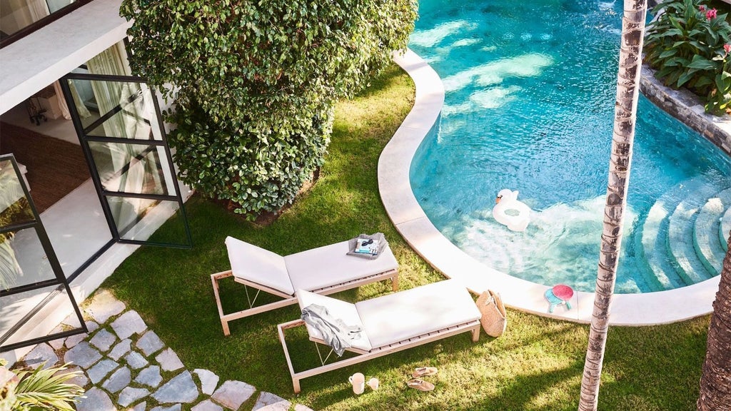 Elegant Mediterranean-style hotel room with white decor, plush king bed, ocean view balcony, and coastal Spain landscape at Bel Air suite