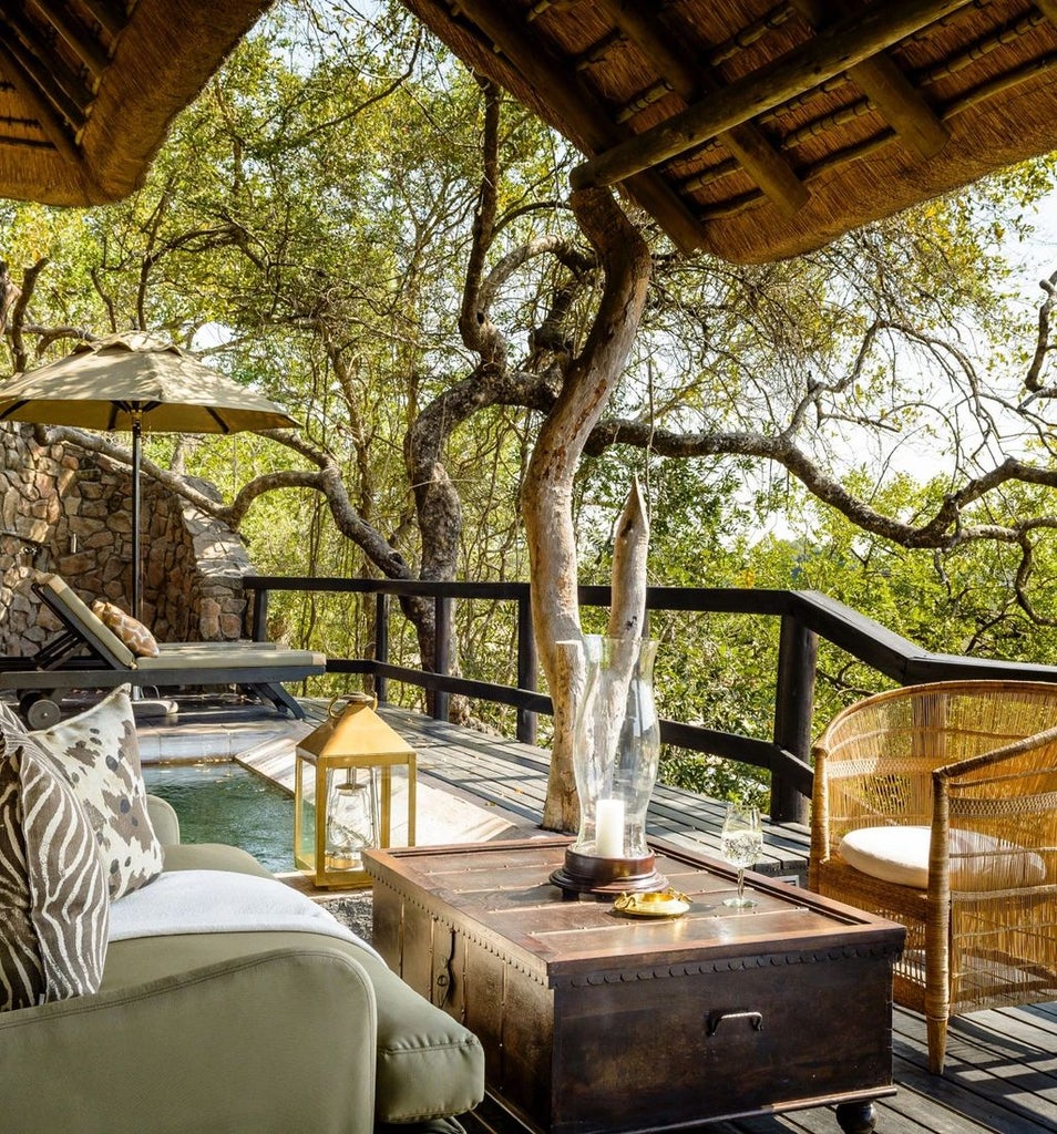 Luxurious outdoor deck of Singita Ebony Lodge overlooking African savanna, with private plunge pool and designer lounge furniture at sunset