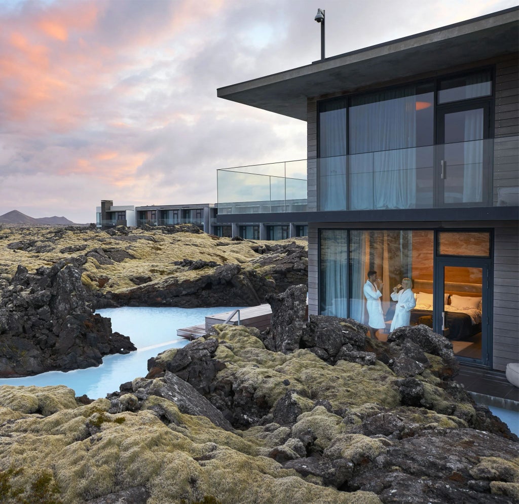 Luxurious scenset retreat nestled in dramatic Icelandic landscape, featuring minimalist Nordic design with floor-to-ceiling windows overlooking rugged volcanic terrain and serene coastline