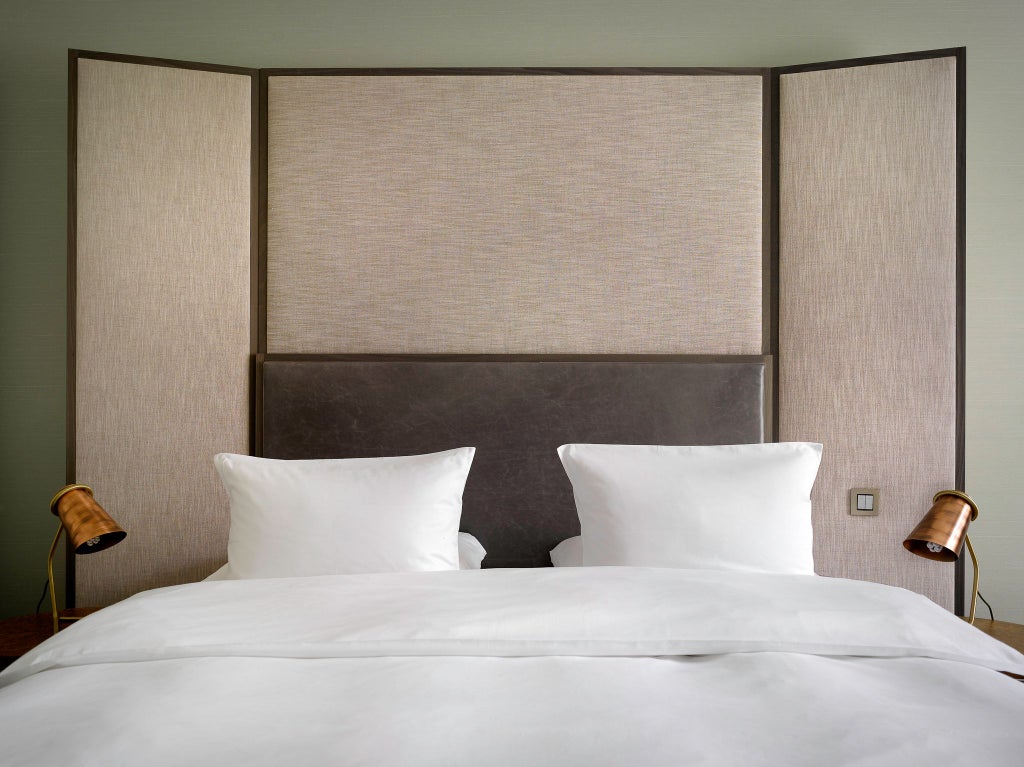 Elegant queen bedroom in scenset Hotel with plush white linens, modern dark wood furniture, and soft ambient lighting in Prague, Czech Republic