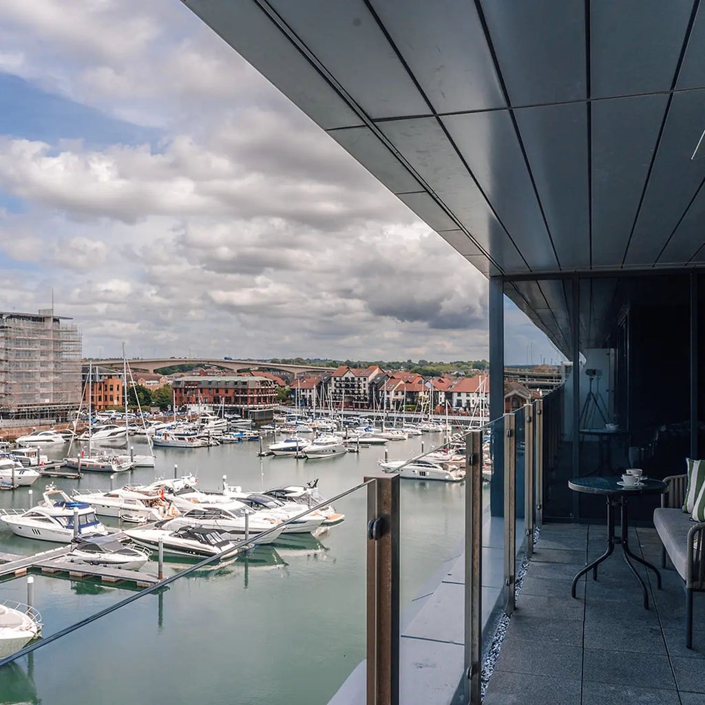 Luxurious Marina View Suite at Harbour Hotel Southampton, featuring contemporary decor, expansive balcony, and panoramic waterfront scenery with modern nautical ambiance